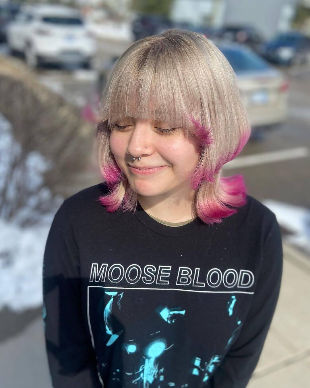 Icy blonde jellyfish haircut with playful pink tips, a soft straight-across fringe, and a sleek bob style.