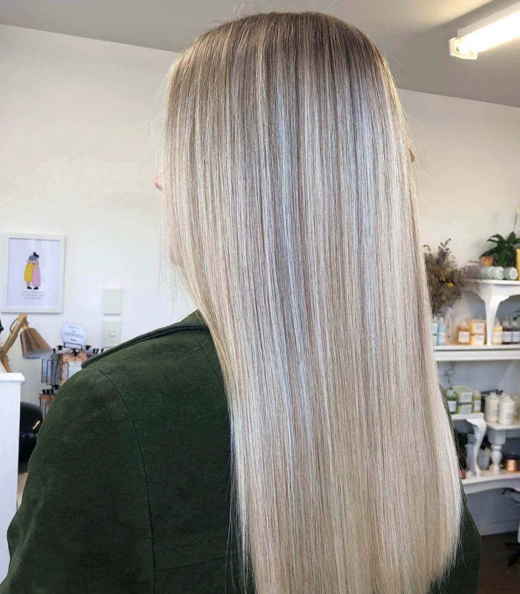 Long straight hair with icy blonde balayage starting from darker roots.