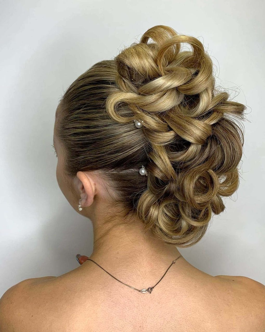 Intricate loops and curls with small pearl pins.