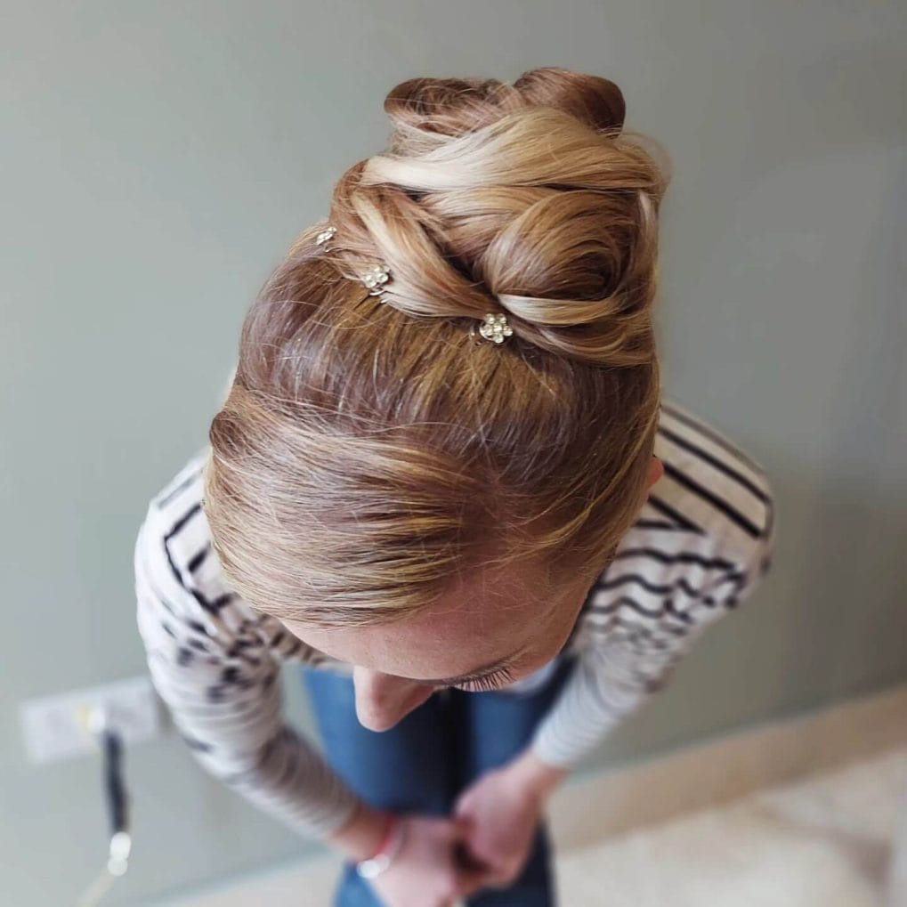 Intricate twisted updo with delicate floral pins.