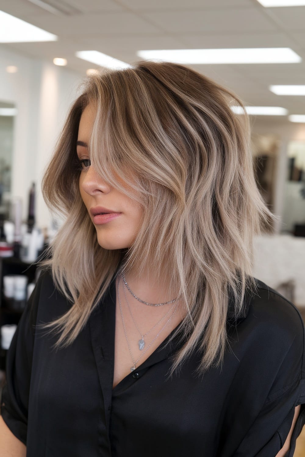 A modern layered haircut with soft waves and highlights, showcasing a stylish look.