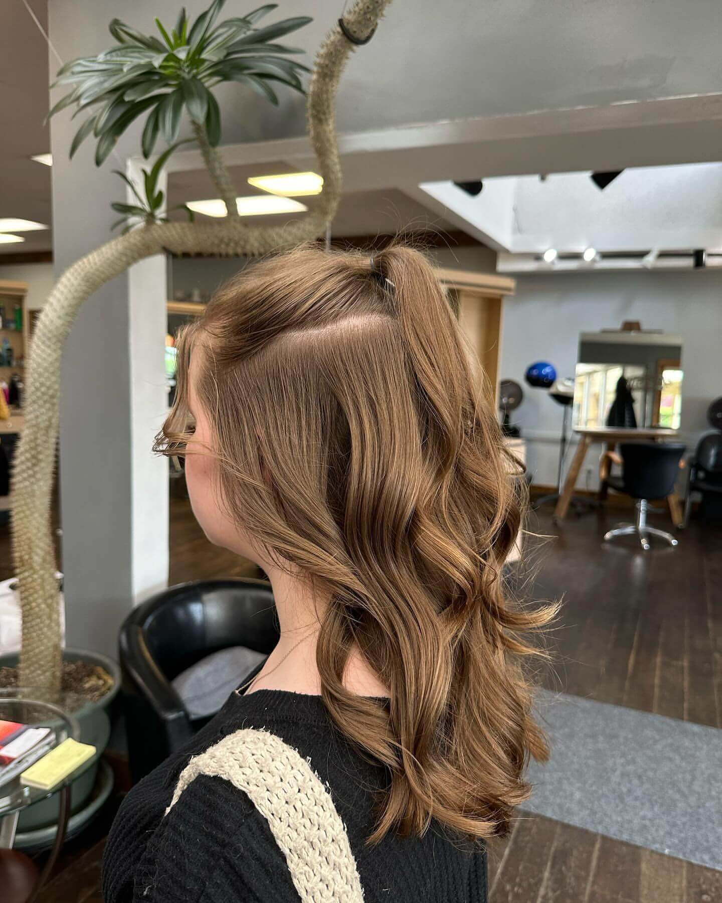 Light brown hair with loose waves and a high half-ponytail