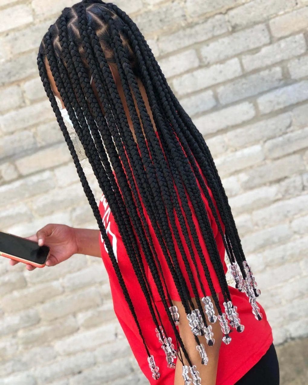 Thick, long black braids enhanced with transparent cylindrical beads.