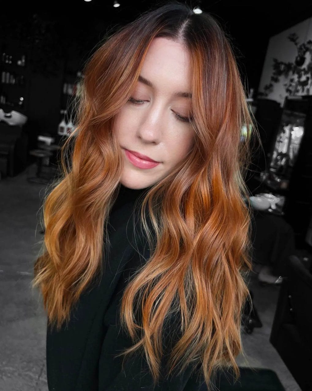 Long, layered cut with shadow root in warm copper and blonde tones.