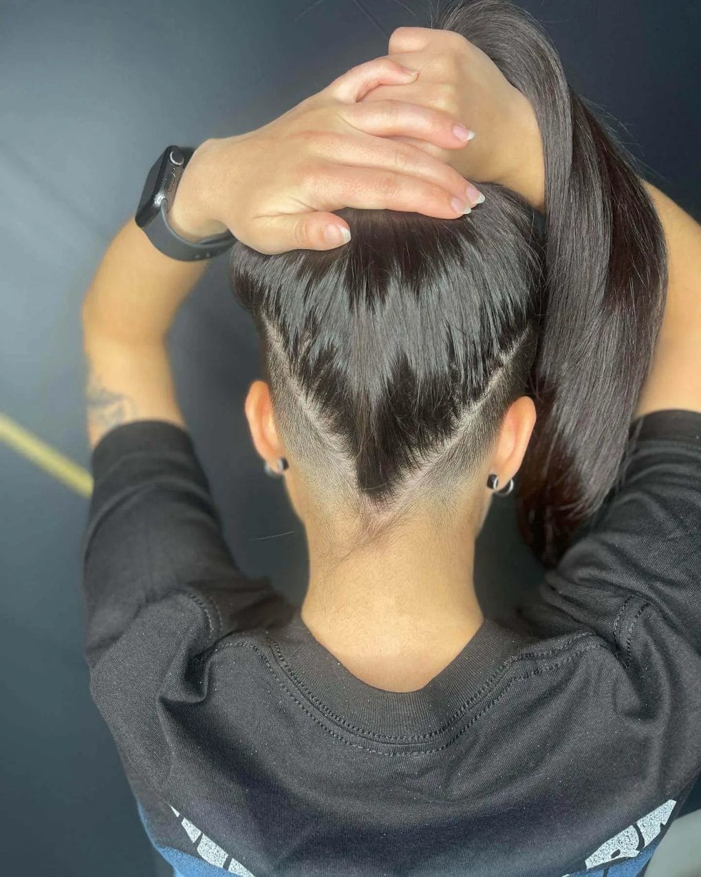 Sleek long ponytail with a hidden undercut detailed with sharp, angular lines beneath.
