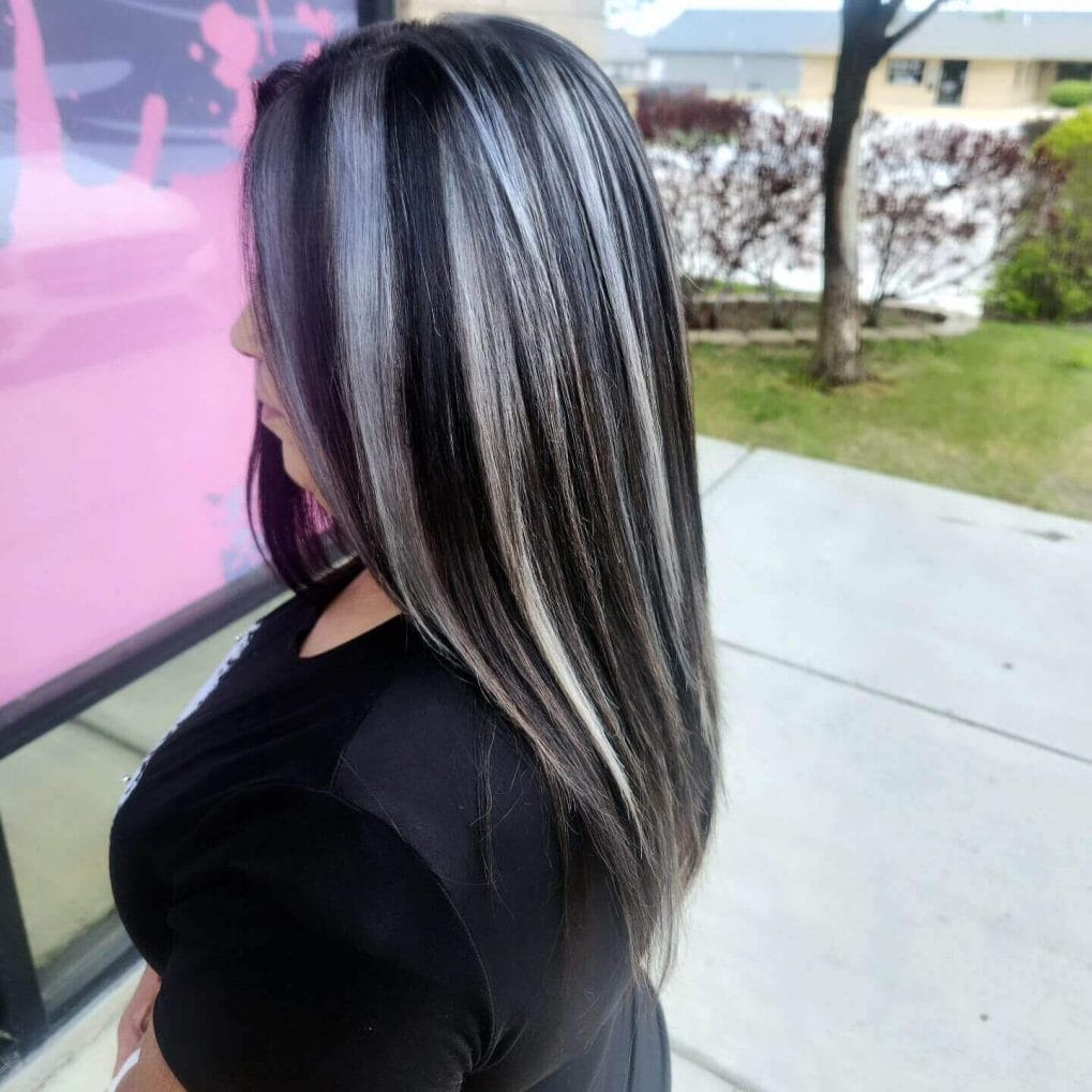 Long sleek hair with silver and black chunky highlights for a modern appearance