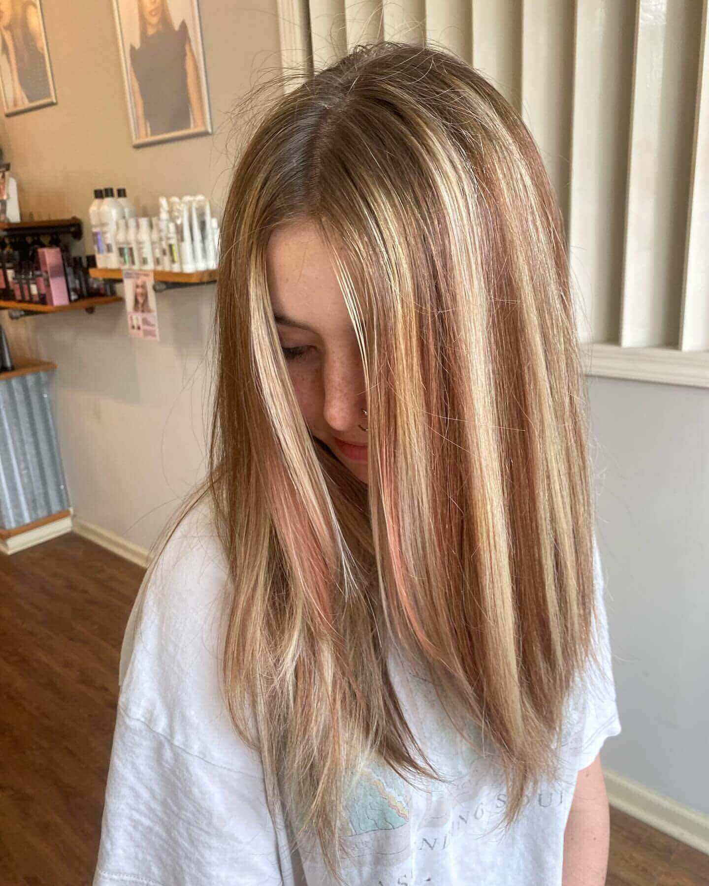 Long straight hair with soft blonde and light brown chunky highlights for a relaxed look