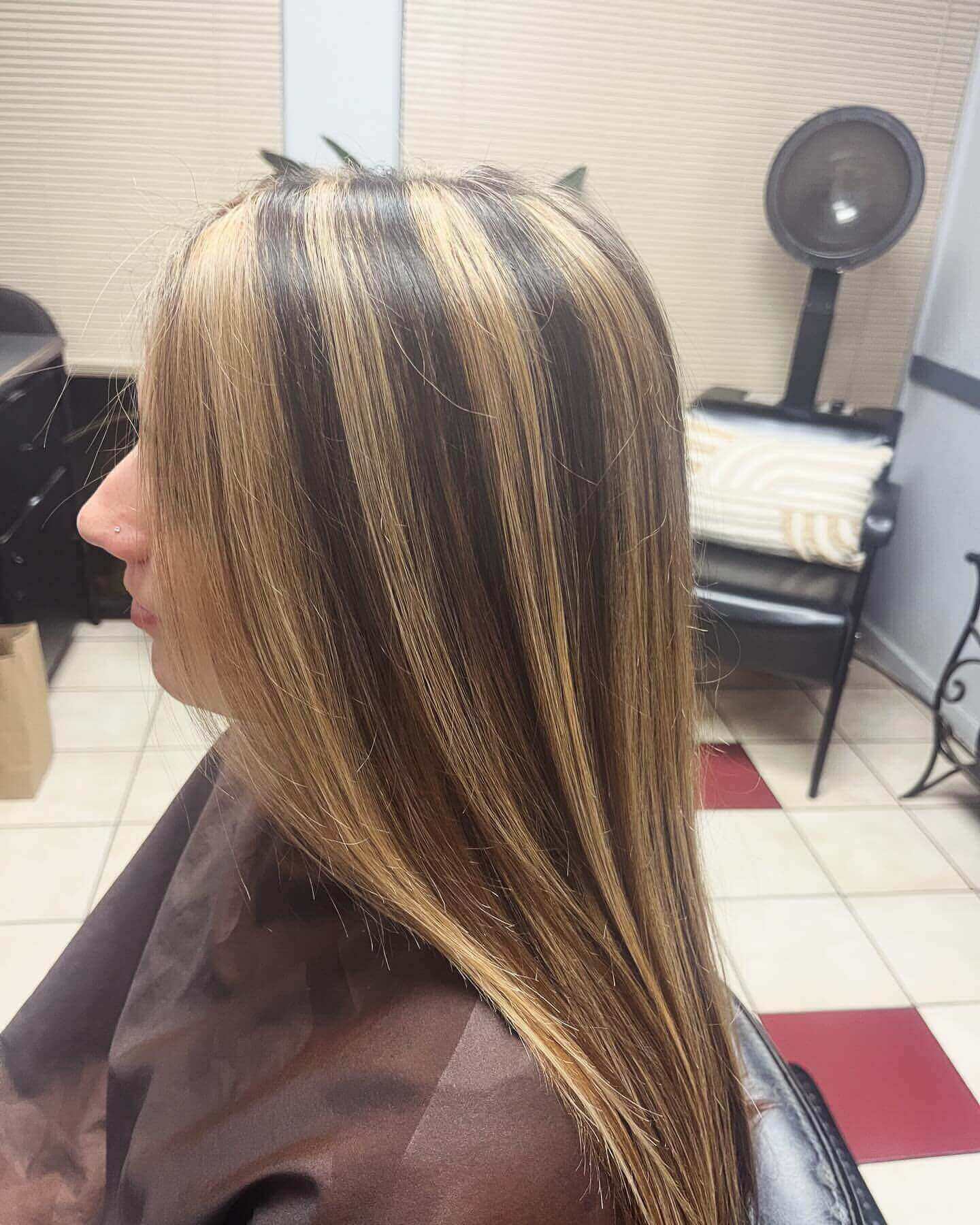 Long straight hair with blonde and light brown chunky highlights for a chic finish