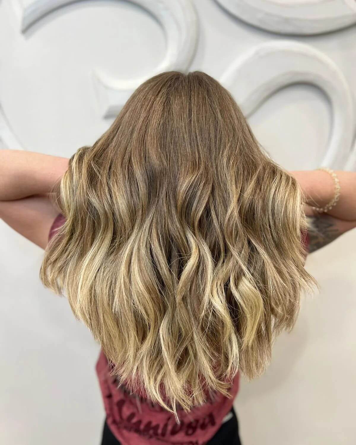 Long wavy layers with warm blonde and light brown balayage