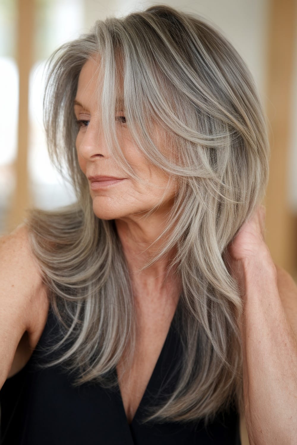 A woman with long layers and subtle highlights, showcasing a graceful hairstyle.