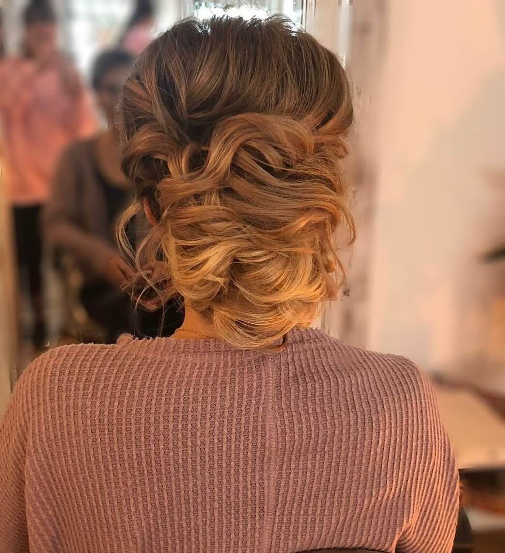 Loose voluminous updo with balayage curls.
