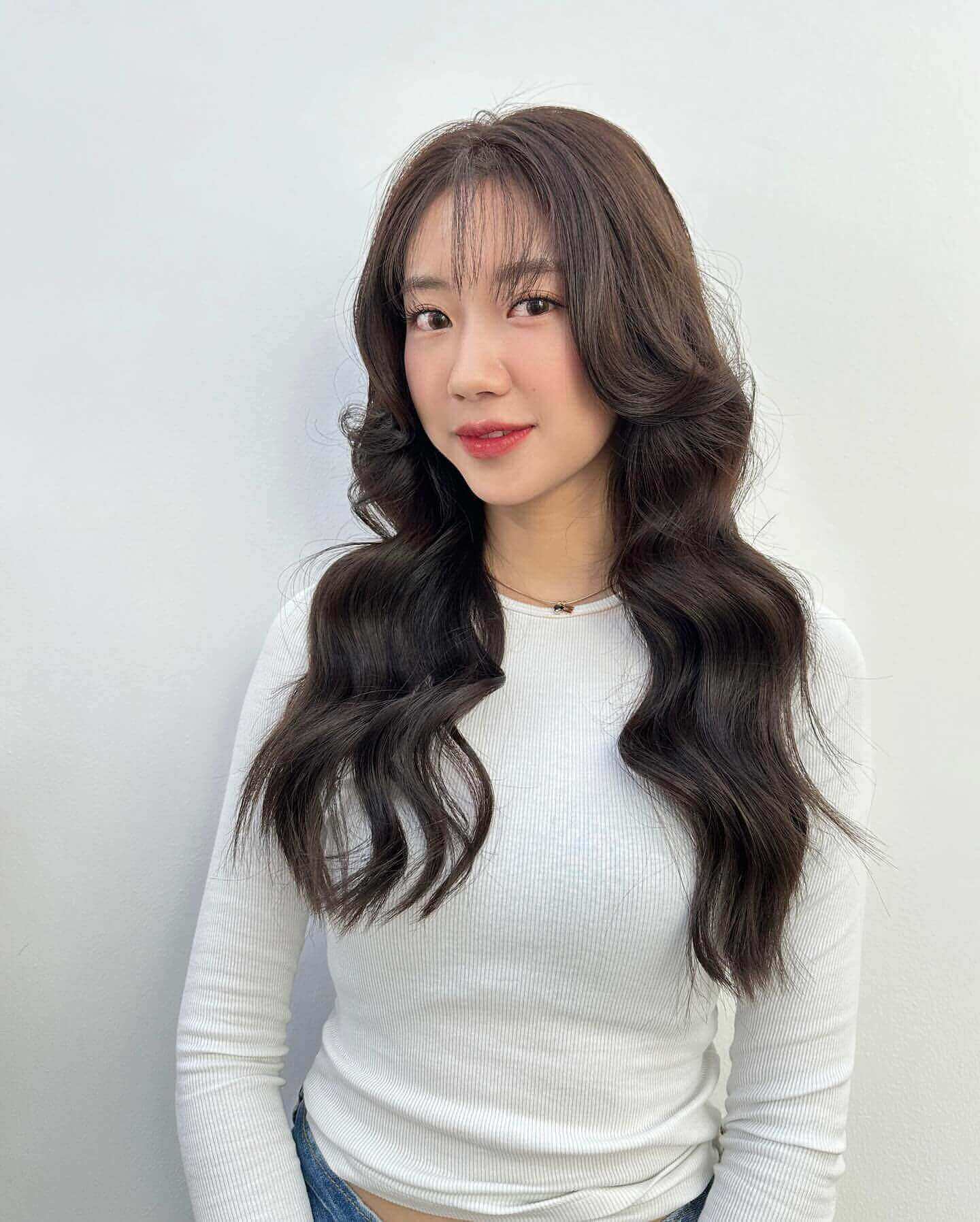 Loose wavy dark brown hair with see-through bangs