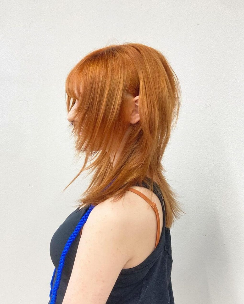 Luminous copper-toned sleek jellyfish haircut with fine fringe and softly curving layers.