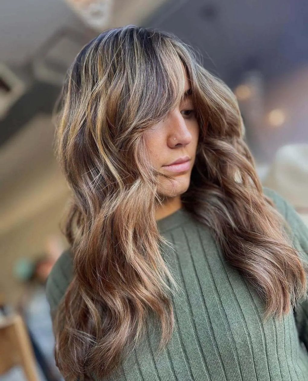 Lush voluminous look with blonde and light brown highlights on hair.
