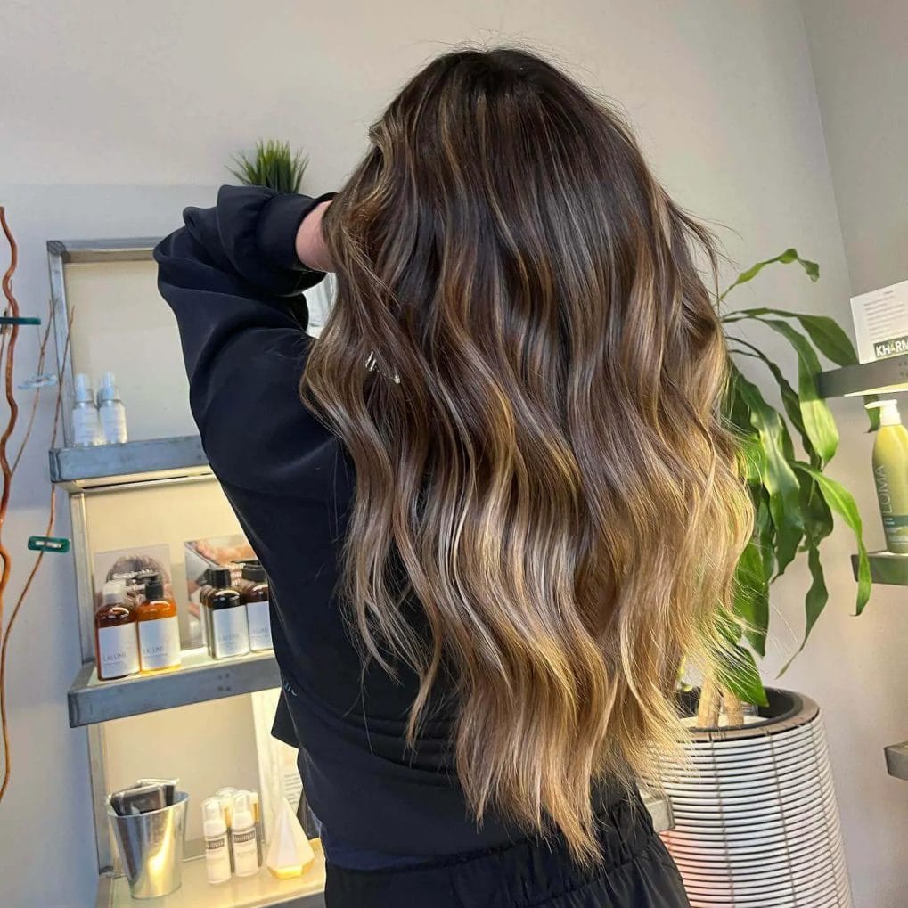 Luxurious long layers with golden sheen highlights on hair.