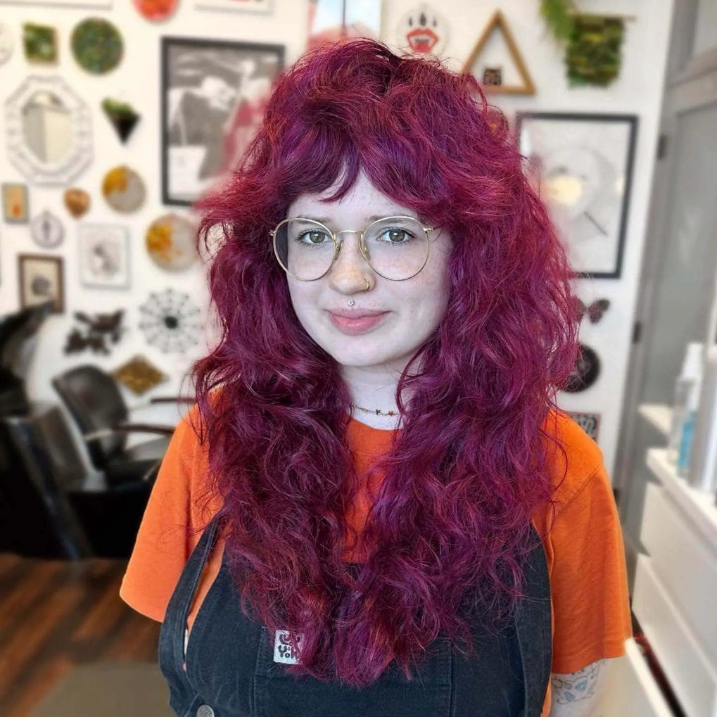 Bold magenta curls with tousled bangs adding sass to round faces.