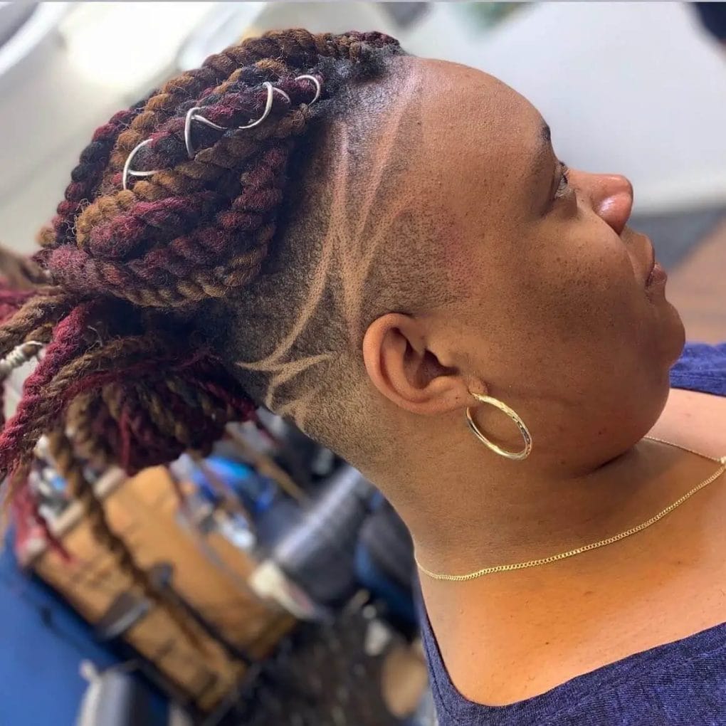 Chunky, maroon-colored twists with intricate lines and curves etched into the undercut.
