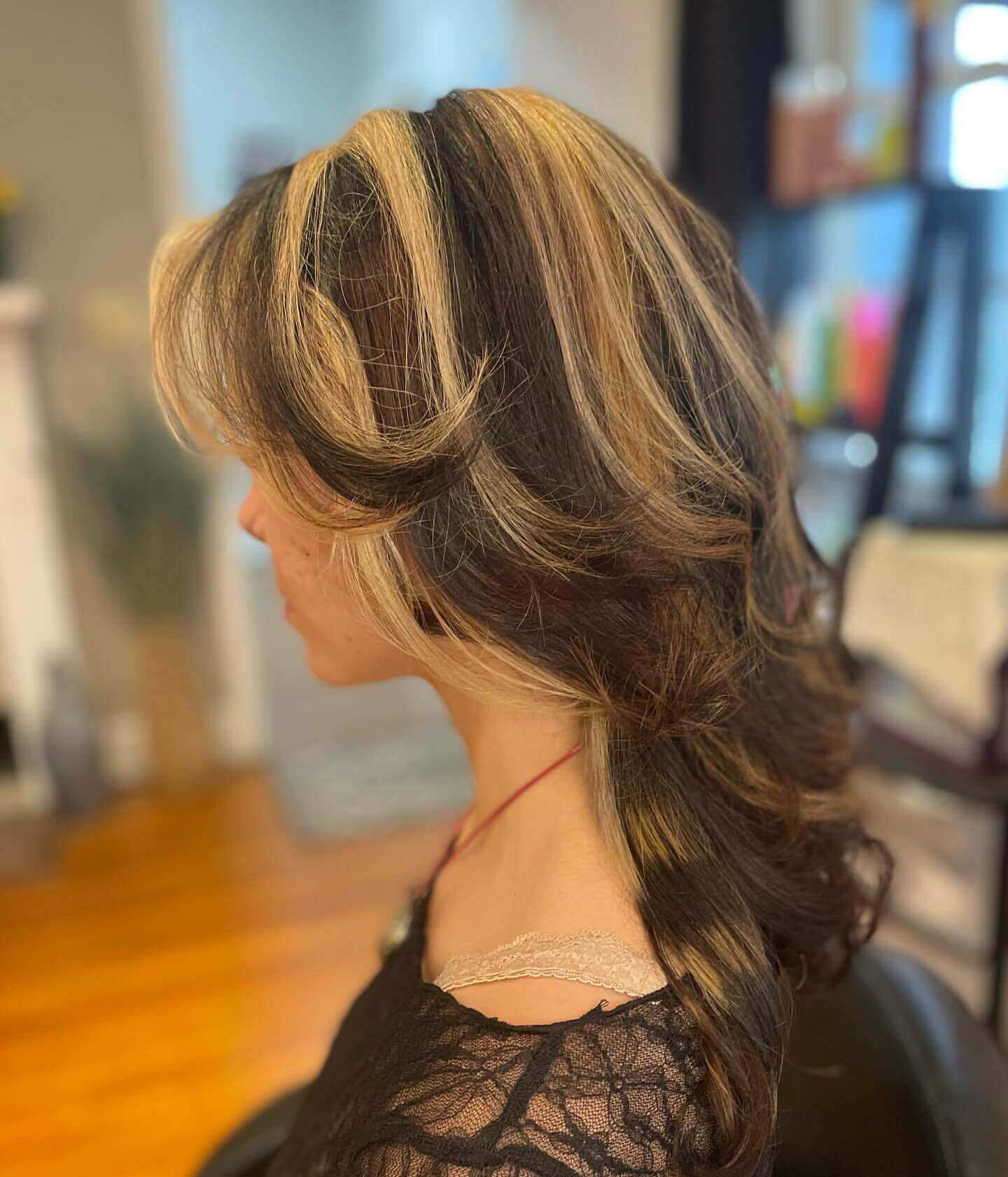 Medium layered hair with blonde and dark brown chunky highlights adding texture