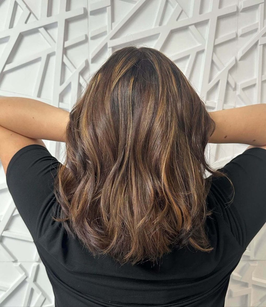 Medium-length layered cut with subtle highlights on hair.