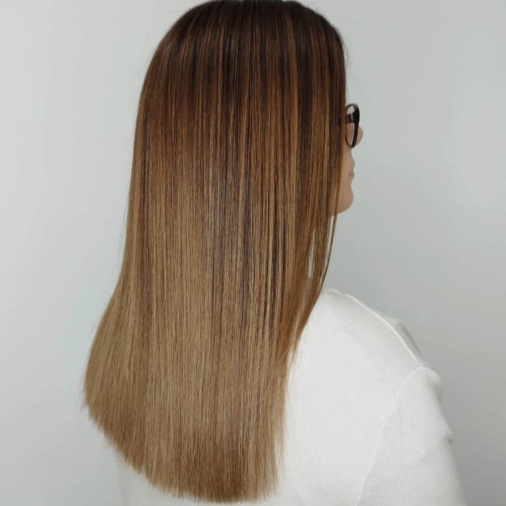 Medium-length straight hair with rich brown and caramel balayage