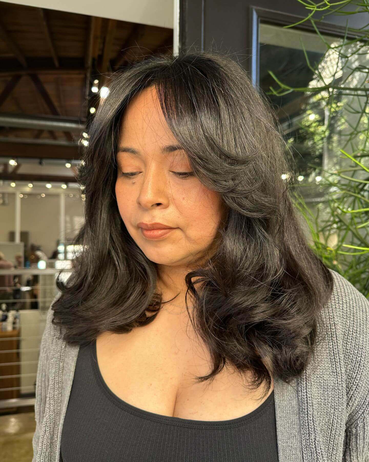 Medium loose curls with 90s curtain bangs