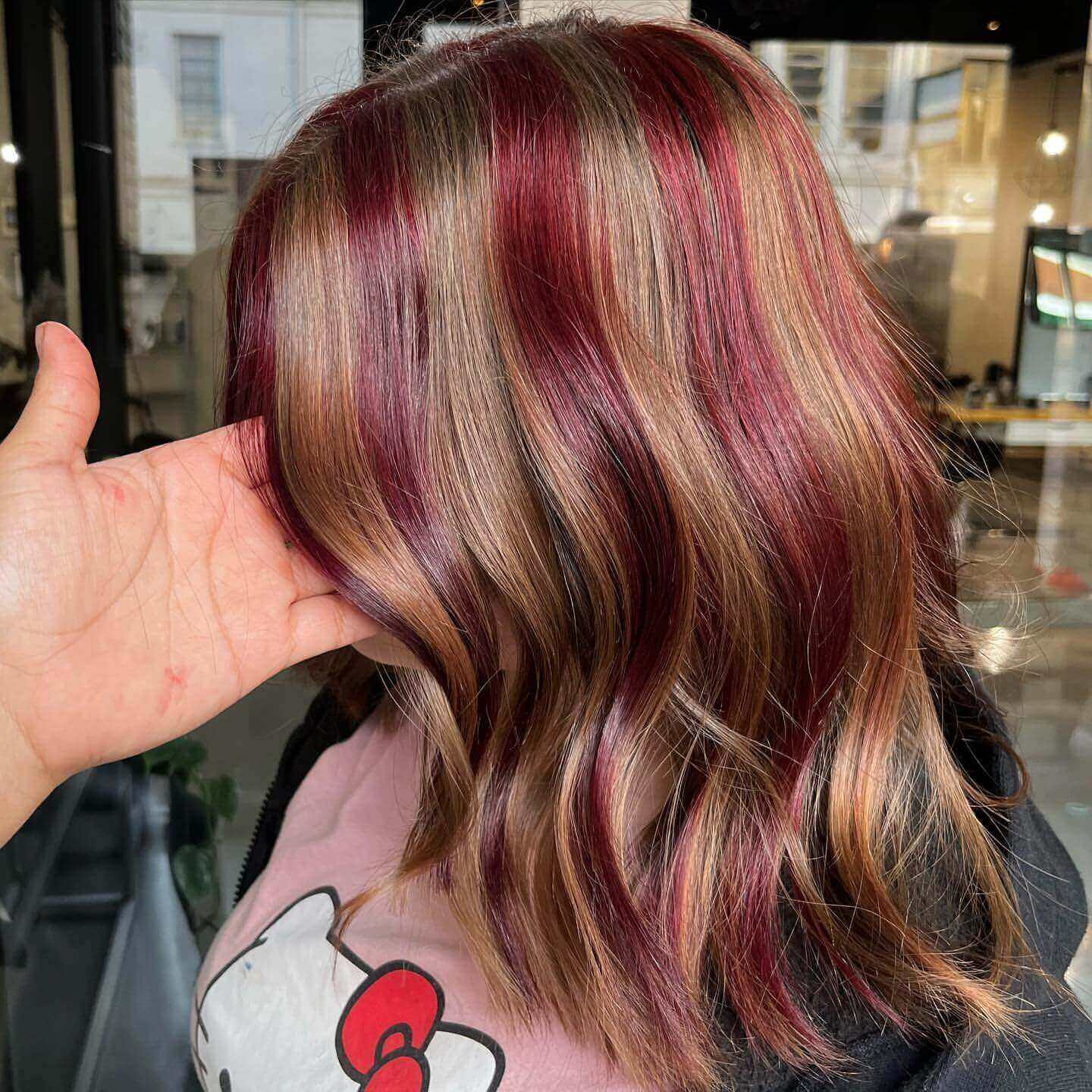 Medium wavy hair with deep red and brown chunky highlights for a stylish effect