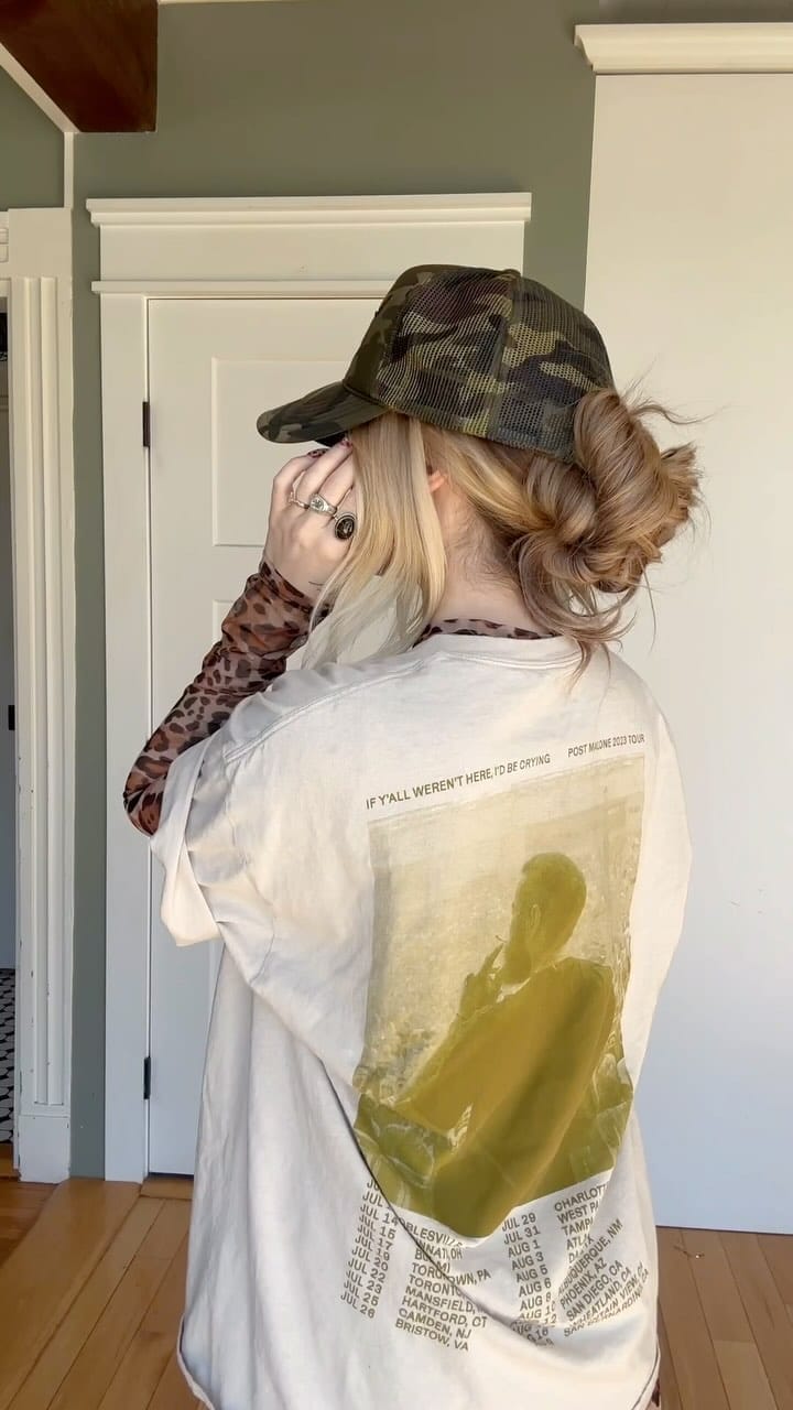 Messy bun under a camouflage cap with mixed blonde tones for softball