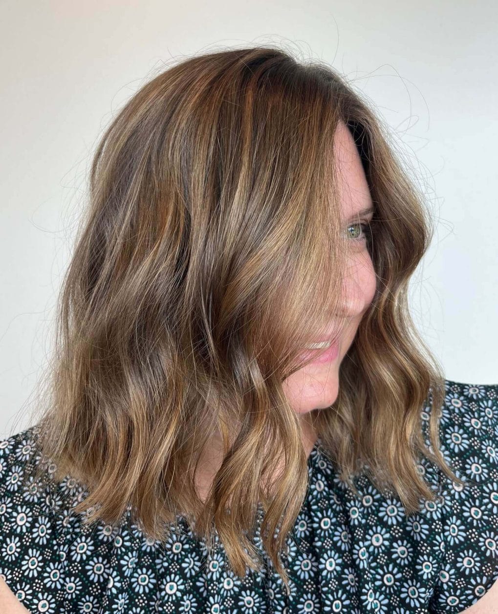 Mid-length cut with honeyed balayage highlights on brunette hair.