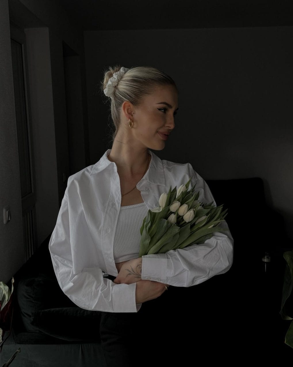 Minimalist high bun accessorized with a white scrunchie