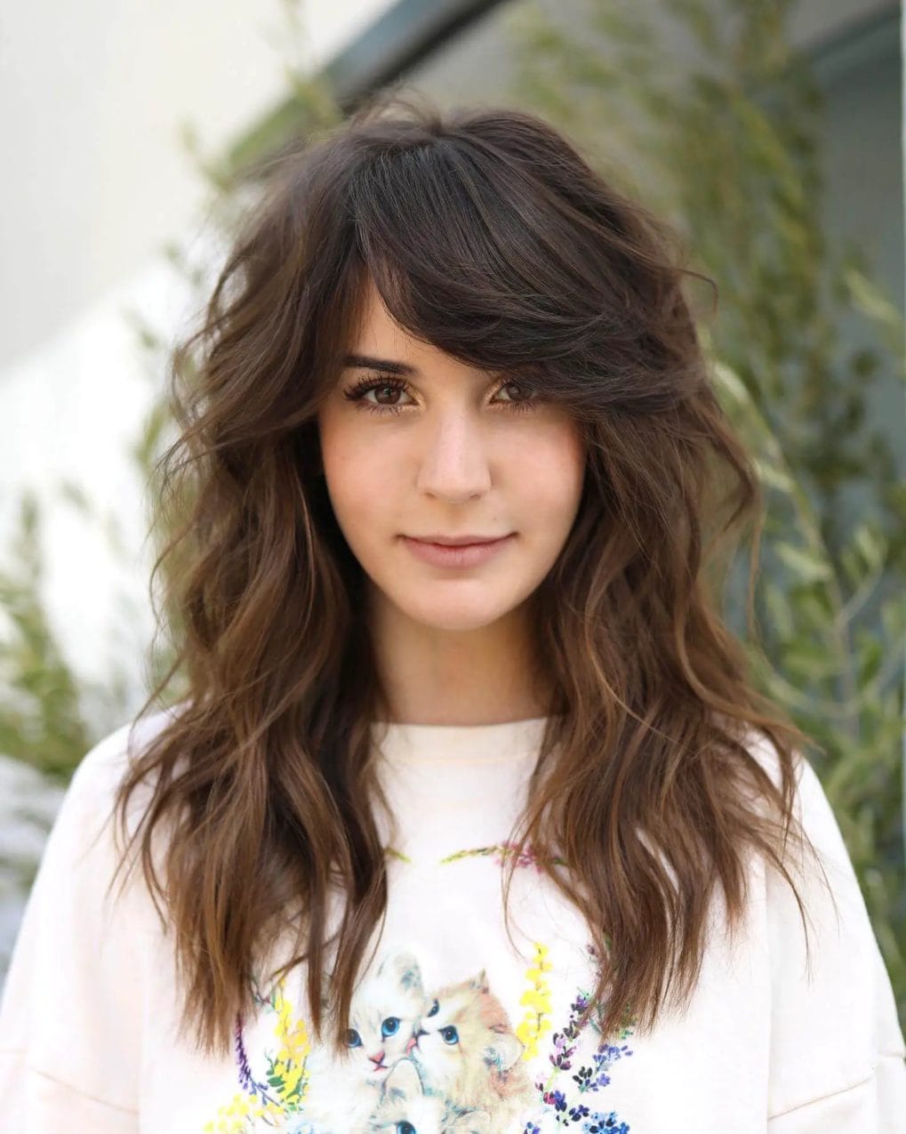 Rich mocha waves with side-swept feathered fringe for round faces.