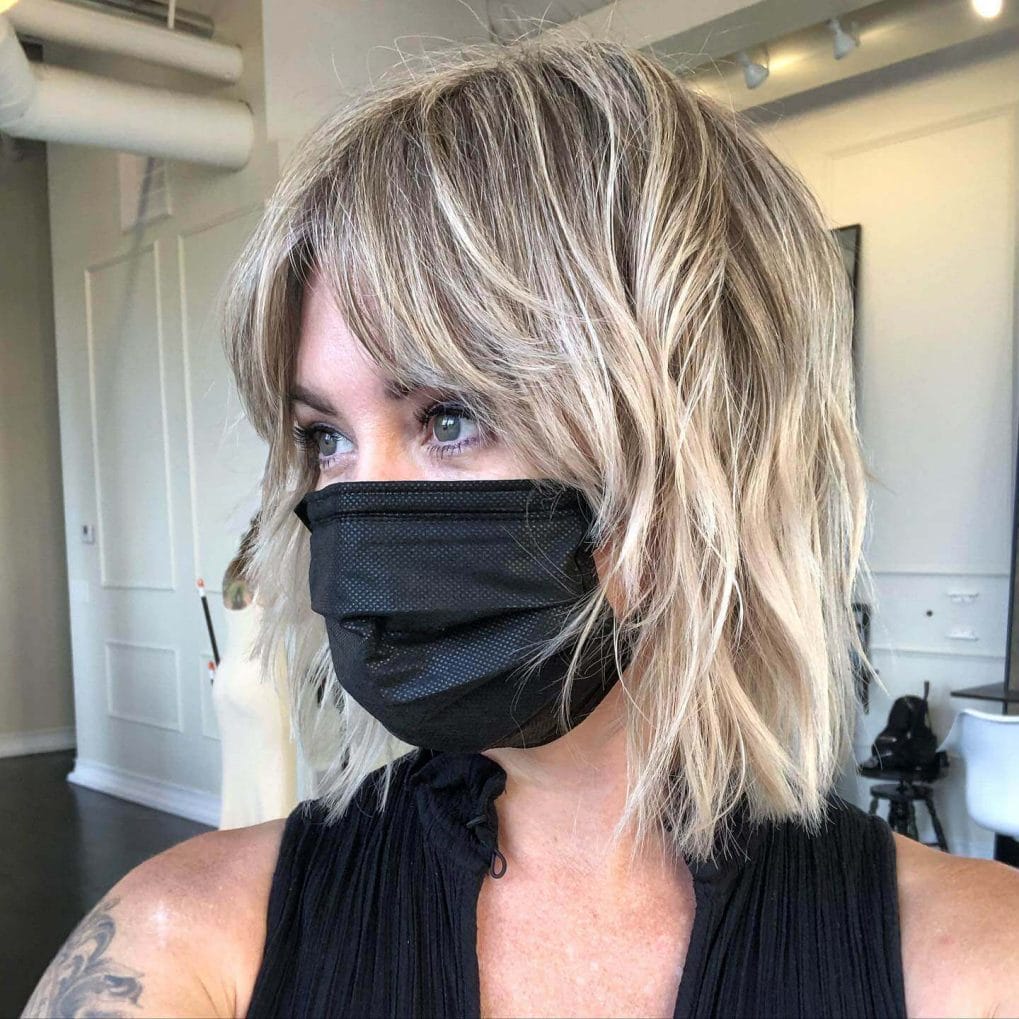 Modern bob with textured finish and soft, sun-kissed curtain bangs.