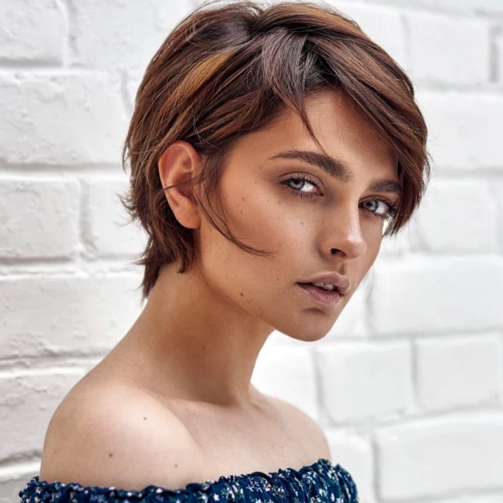 Textured pixie bob with brown tones and side-swept bangs for a soft, modern twist