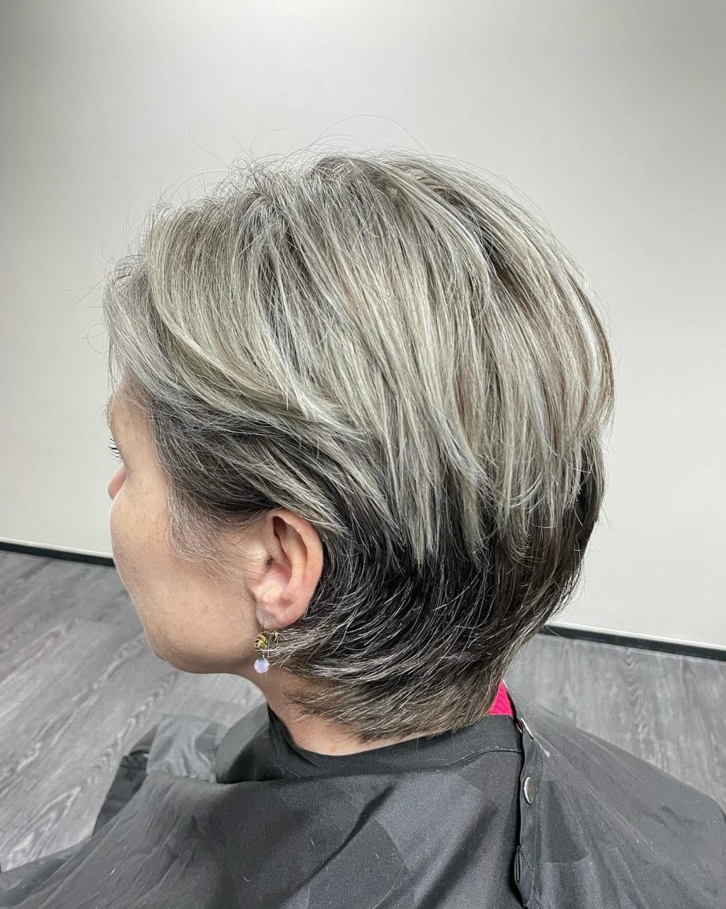 Modern voluminous pixie bob in silver and ash blonde with forward-swept hair framing the face