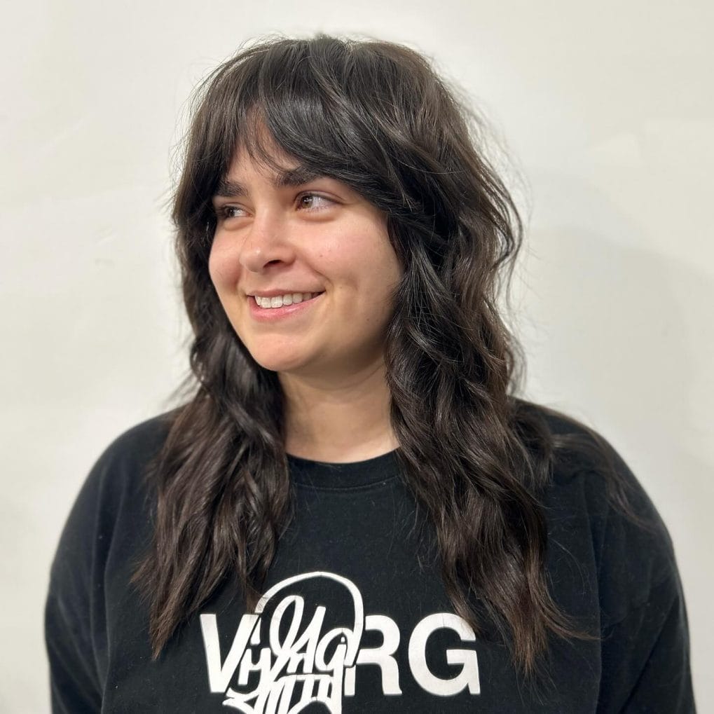 Natural and easy dark wavy shaggy mullet with thick, wavy bangs