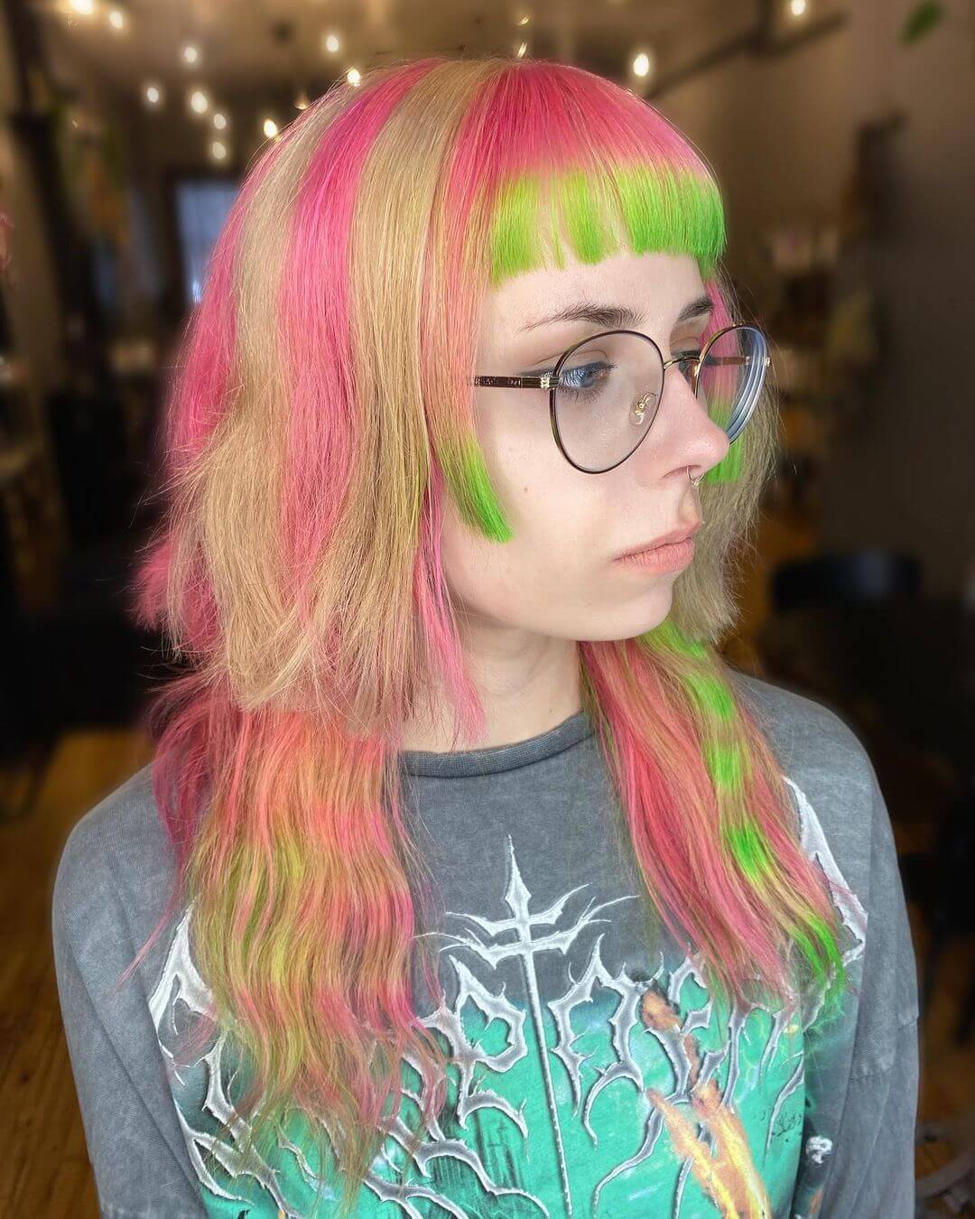 Vibrant jellyfish haircut with neon pink and lime green swirls, complemented by sharp bangs.