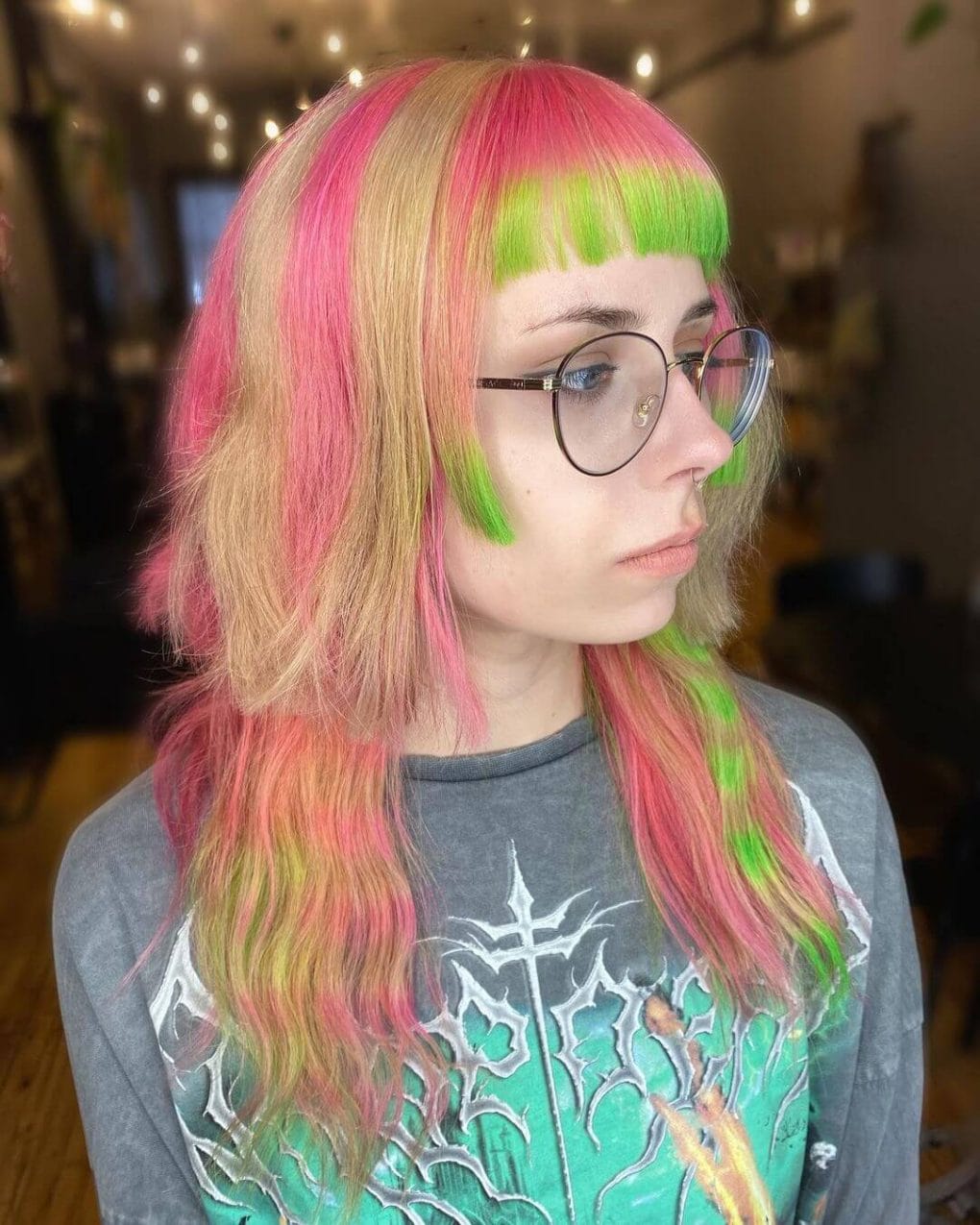 Vibrant jellyfish haircut with neon pink and lime green swirls, complemented by sharp bangs.