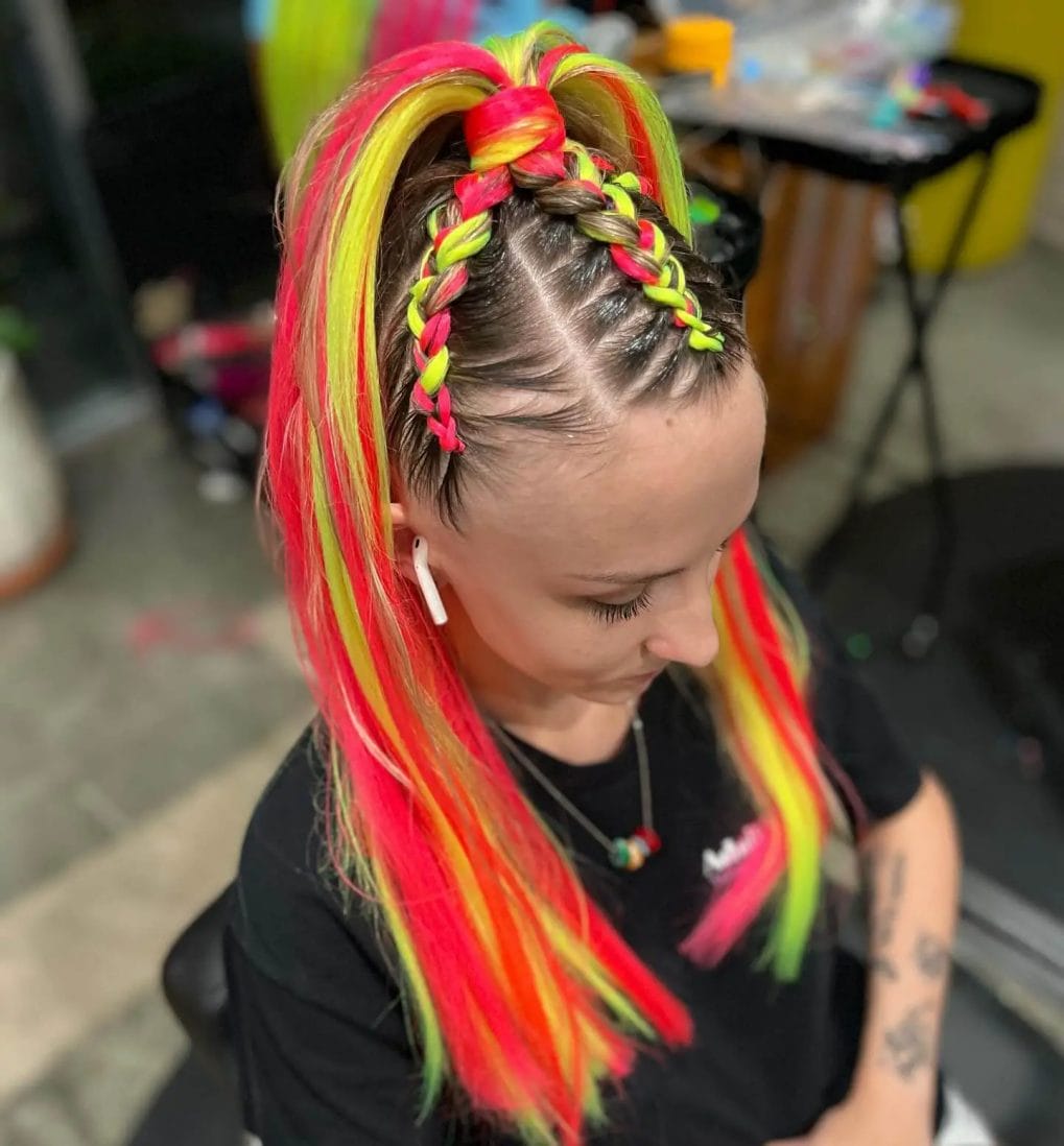 High-contrast neon yellow and hot pink hair with a central French braid, showcasing festival vibrancy.