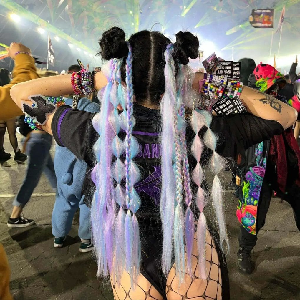 Pastel purple and blue braids twisted with black hair into buns