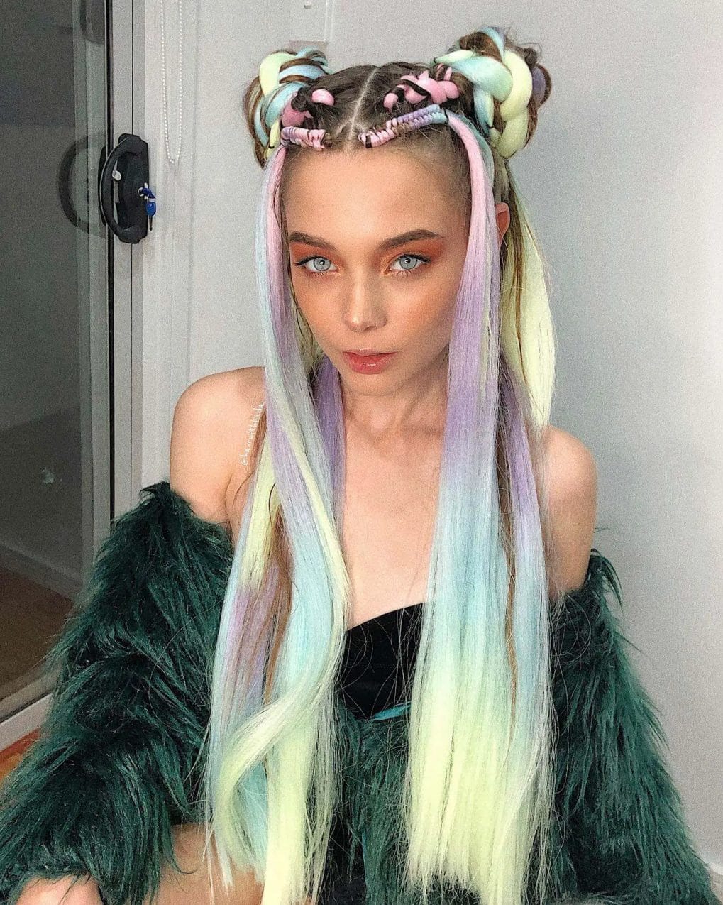 Sleek locks in pastel rainbow hues with playful space buns, perfect for making a statement at festivals.