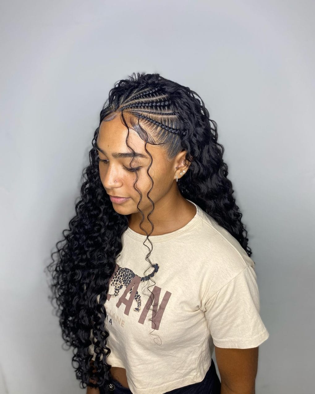 Natural curls fall from beautifully patterned braids with a single curly tendril