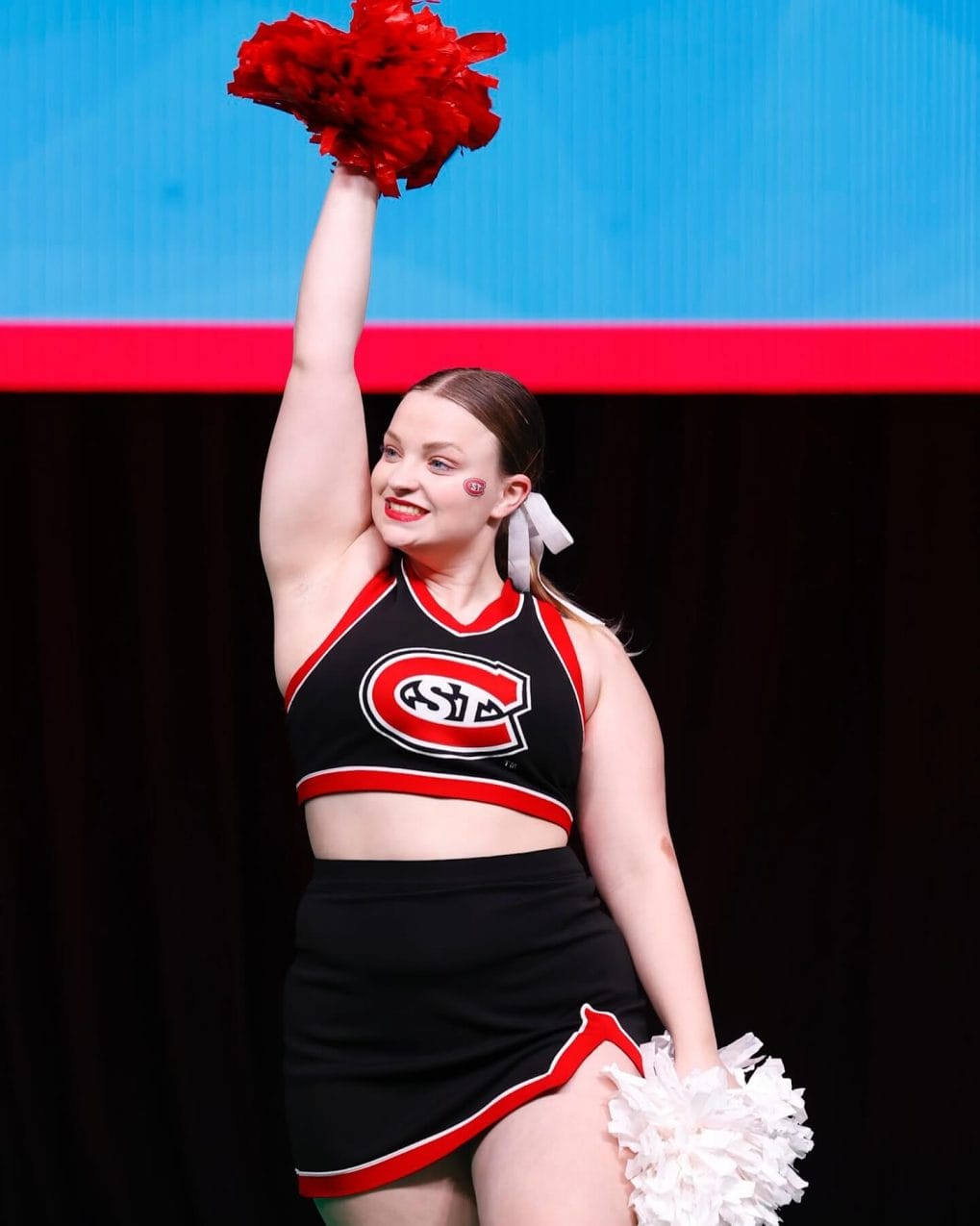 Brown hair in high ponytail with white bow for cheerleading