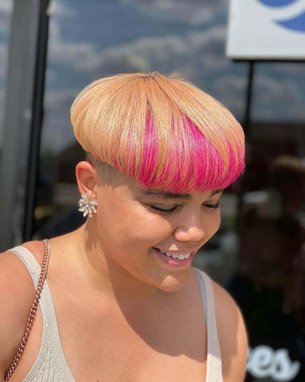 Mushroom cut with bold color transition from blonde to pink ends.