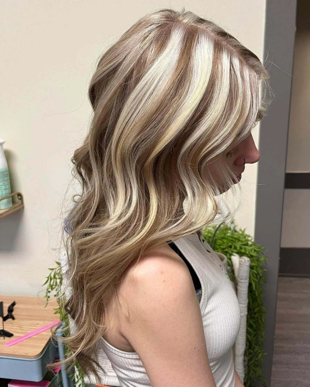 Platinum blonde chunks with sandy base, loose waves, light and beachy look.