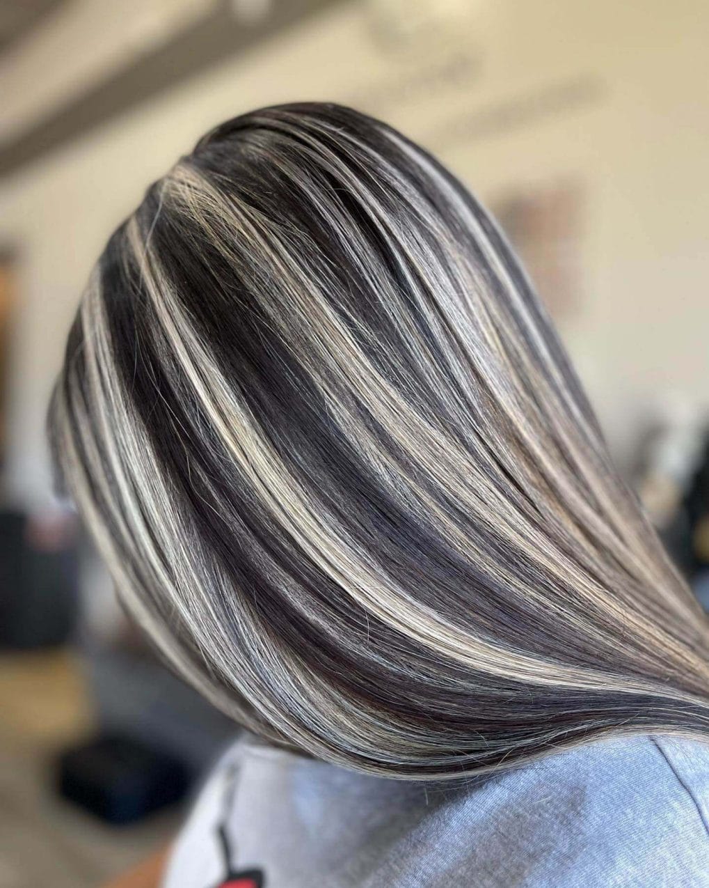 Bold platinum streaks in a sleek, straight dark hairstyle, uniform length.