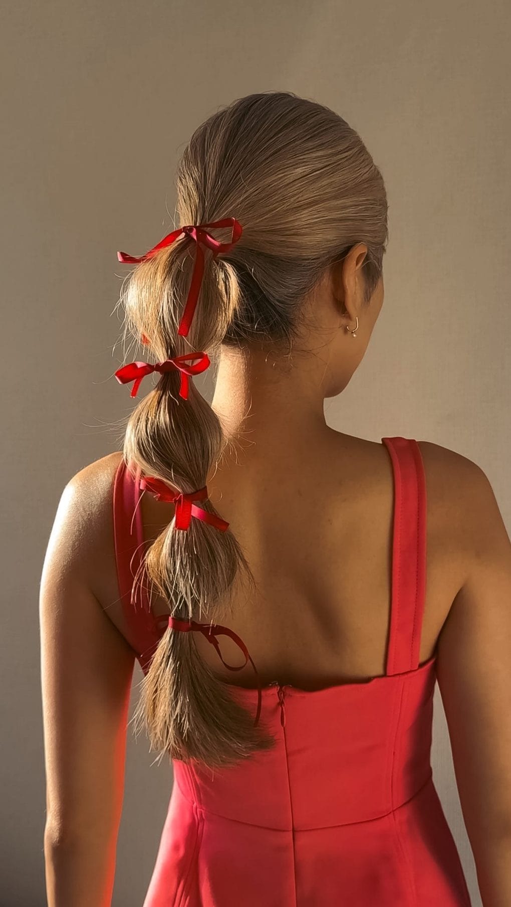 Playful red-ribboned ponytail for sunny days
