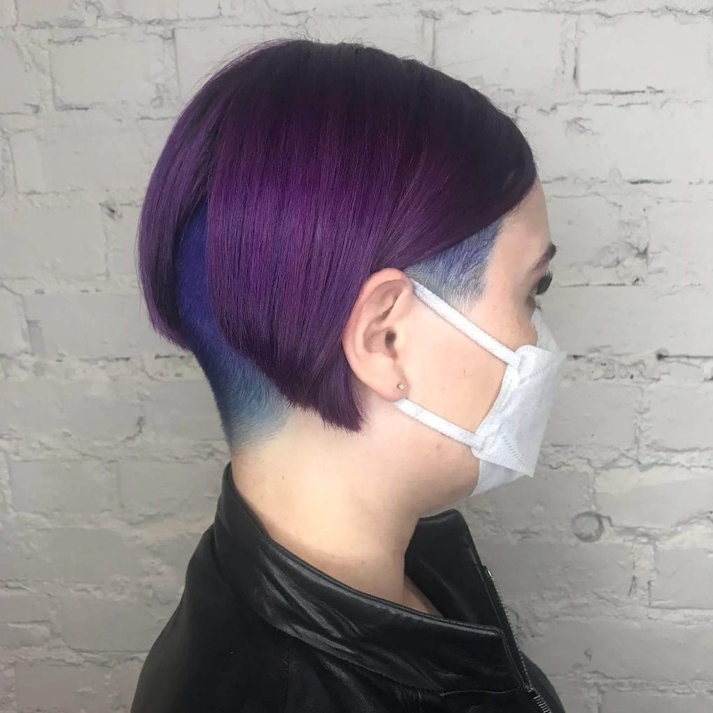 Chic rounded bob in vibrant purple fading into a cool blue undercut with an electric contrast.
