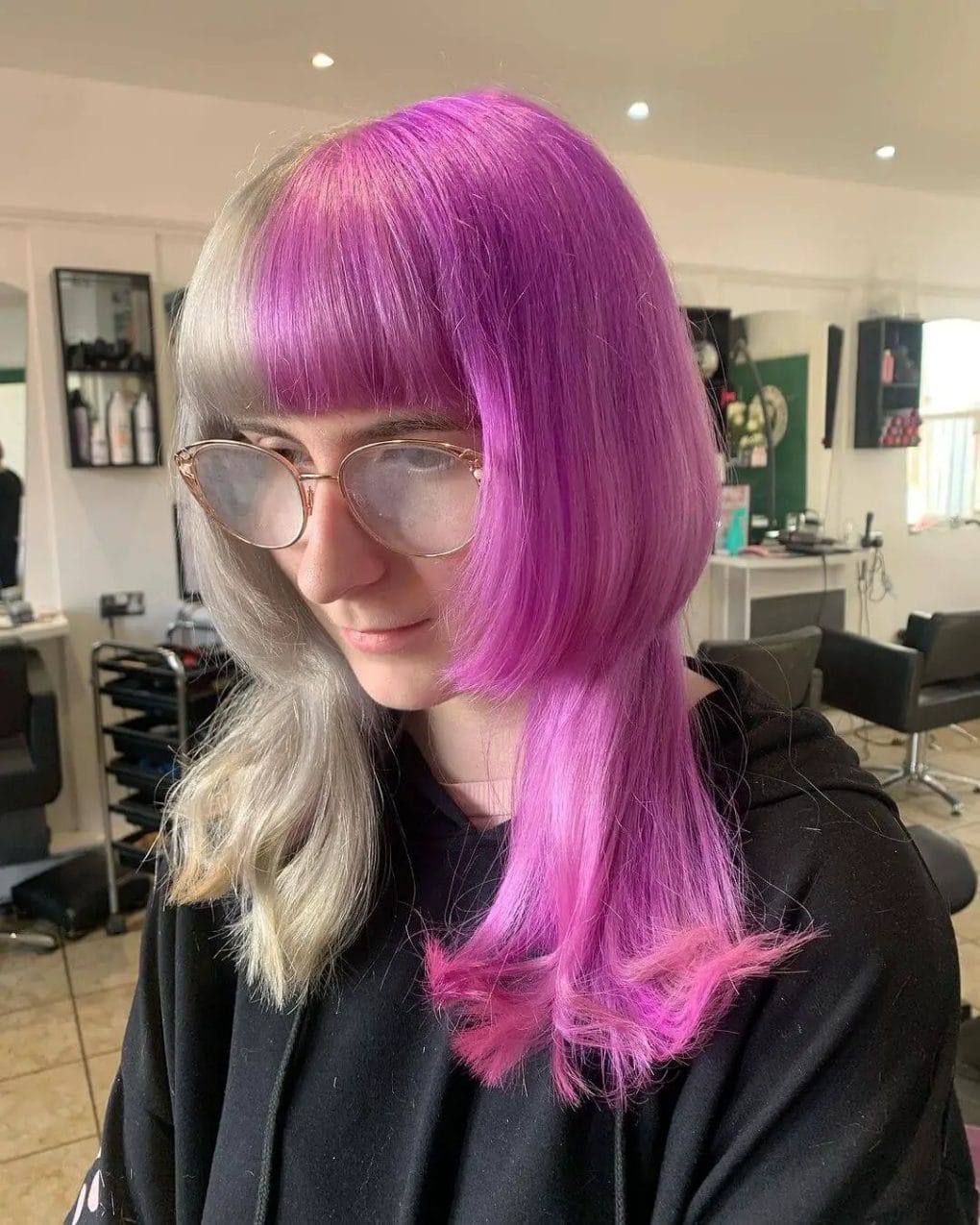 Sleek jellyfish haircut transitioning from vibrant purple roots to soft silver hues with a straight full fringe.