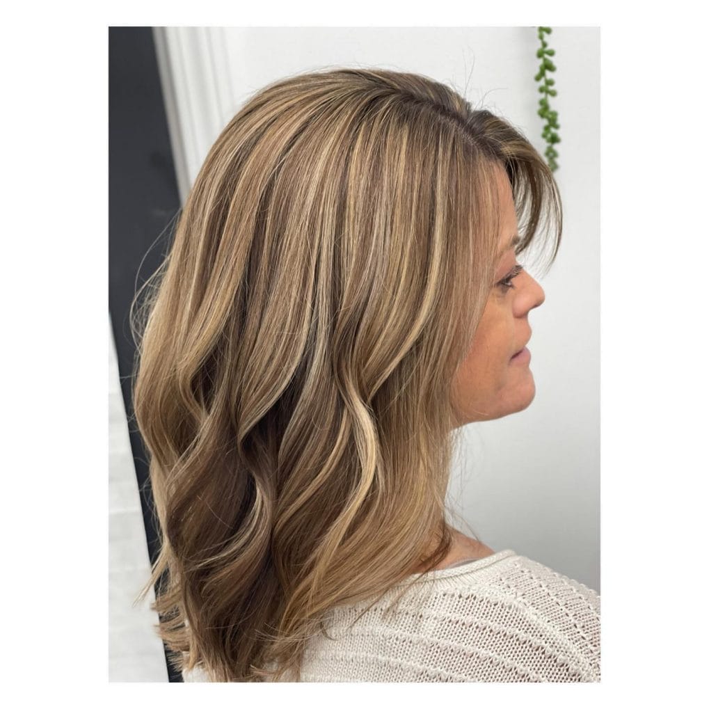 Radiant medium-length hair with flowing waves and blended highlights.