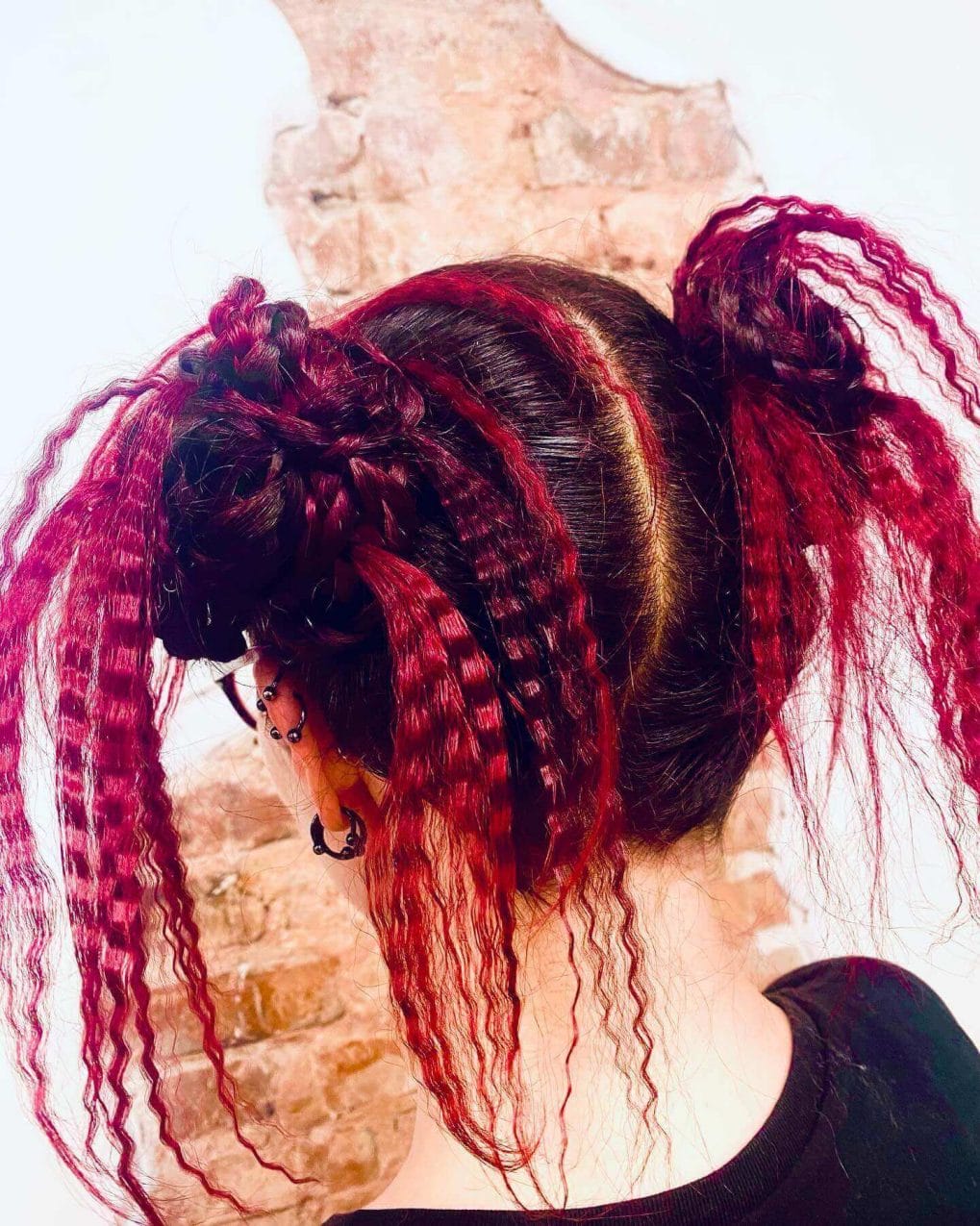 Red and black braided updo with loose crimped strands