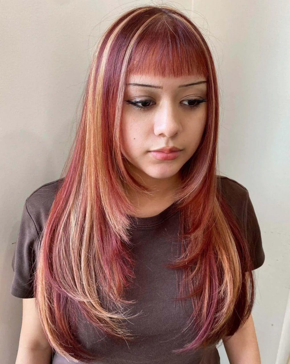 Fiery red and blonde highlights in straight, layered cut with full fringe.